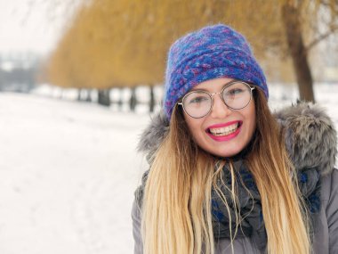 İçinde belgili tanımlık soğuk mavi bir şapka ve gözlük yuvarlak güzel mutlu kız