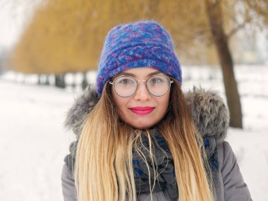 İçinde belgili tanımlık soğuk mavi bir şapka ve gözlük yuvarlak güzel mutlu kız