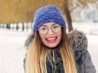 İçinde belgili tanımlık soğuk mavi bir şapka ve gözlük yuvarlak güzel mutlu kız
