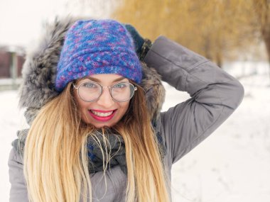 İçinde belgili tanımlık soğuk mavi bir şapka ve gözlük yuvarlak güzel mutlu kız