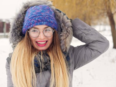 İçinde belgili tanımlık soğuk mavi bir şapka ve gözlük yuvarlak güzel mutlu kız