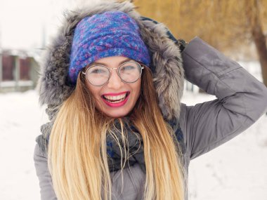 İçinde belgili tanımlık soğuk mavi bir şapka ve gözlük yuvarlak güzel mutlu kız