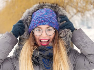 İçinde belgili tanımlık soğuk mavi bir şapka ve gözlük yuvarlak güzel mutlu kız