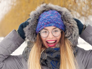 İçinde belgili tanımlık soğuk mavi bir şapka ve gözlük yuvarlak güzel mutlu kız