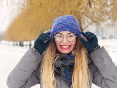 İçinde belgili tanımlık soğuk mavi bir şapka ve gözlük yuvarlak güzel mutlu kız