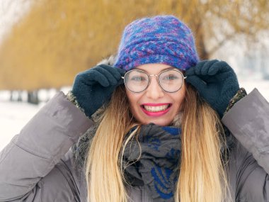 İçinde belgili tanımlık soğuk mavi bir şapka ve gözlük yuvarlak güzel mutlu kız