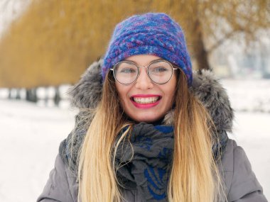 İçinde belgili tanımlık soğuk mavi bir şapka ve gözlük yuvarlak güzel mutlu kız