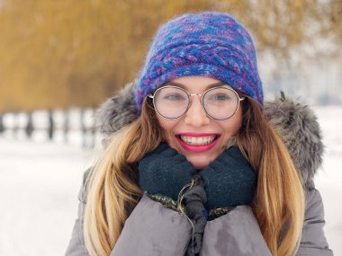 İçinde belgili tanımlık soğuk mavi bir şapka ve gözlük yuvarlak güzel mutlu kız