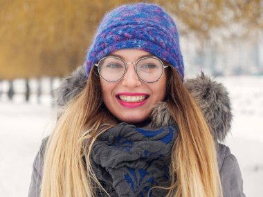 İçinde belgili tanımlık soğuk mavi bir şapka ve gözlük yuvarlak güzel mutlu kız