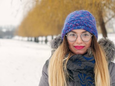 İçinde belgili tanımlık soğuk mavi bir şapka ve gözlük yuvarlak güzel mutlu kız