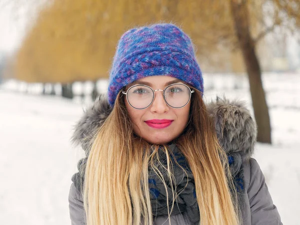 İçinde belgili tanımlık soğuk mavi bir şapka ve gözlük yuvarlak güzel mutlu kız