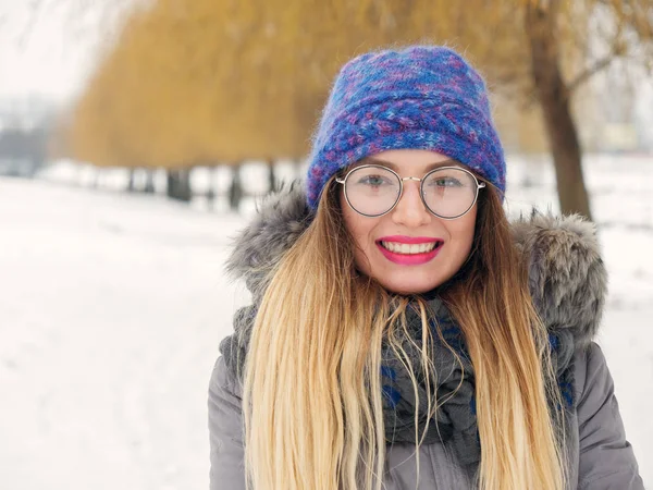 İçinde belgili tanımlık soğuk mavi bir şapka ve gözlük yuvarlak güzel mutlu kız