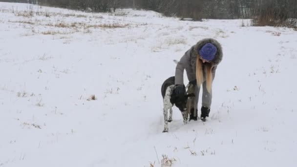 Bella Ragazza Allegra Che Porta Spasso Cane Indicatore Nella Neve — Video Stock