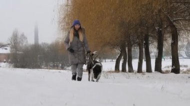 Güzel neşeli kız köpek işaretçi karda yürüyüş.