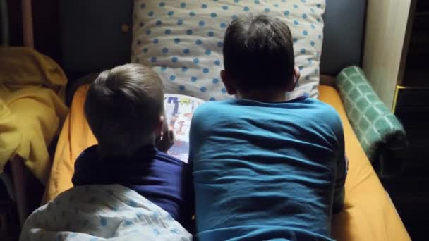 Gyermekek Olvasni Egy Könyvet Ágyban Éjjel — Stock videók