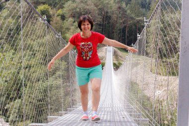 İnsanlar üzerinde bir asma köprü dağlarda Perarollo di Cadore köyü yakınındaki