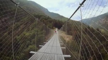 İnsanlar üzerinde bir asma köprü dağlarda Perarollo di Cadore köyü yakınındaki.