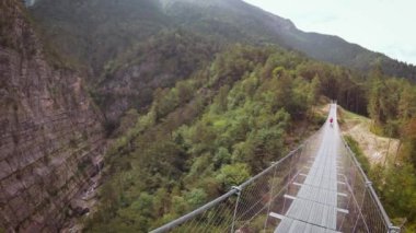 İnsanlar üzerinde bir asma köprü dağlarda Perarollo di Cadore köyü yakınındaki.