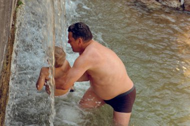 İnsanlar taş doğada bir şelale bir dağ dere banyoları