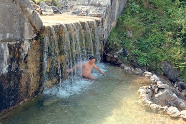 doğa içinde taşlar üzerinde bir dağ dere Falls'daki adam banyoları