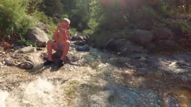 doğada buzlu brook tarafından çocuk oturur.