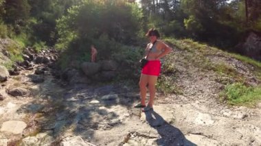 Caralte di Cadore, İtalya - 12 Ağustos 2018: Anne ile oğlu dinlenme Creek dağlarda.