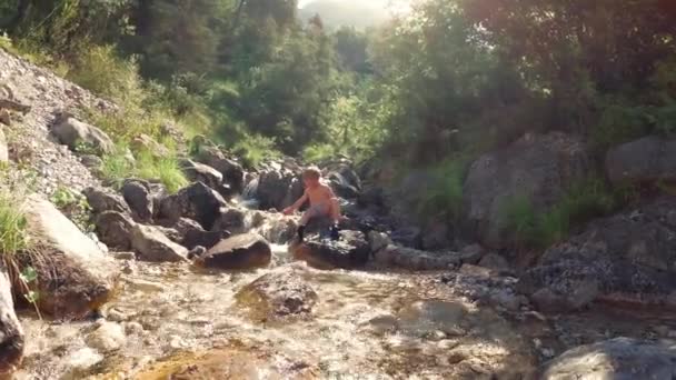 孩子坐在大自然岩石上的溪边 — 图库视频影像