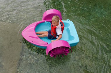 Bebek bir oyuncak bebek tekne yüzer. cazibe.