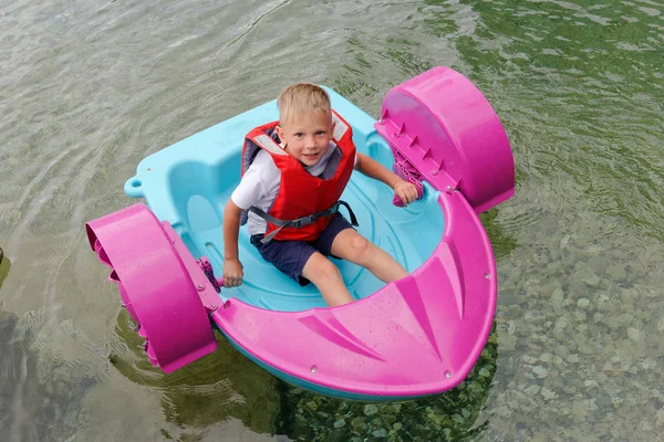 Baby floats on a toy baby boat. attraction. — Stock Photo, Image