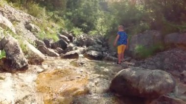 doğada buzlu brook tarafından çocuk oturur.