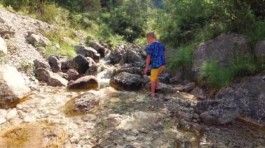 doğada buzlu brook tarafından çocuk oturur.