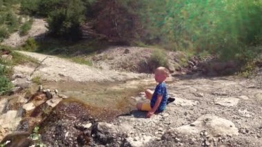 doğada buzlu brook tarafından çocuk oturur.