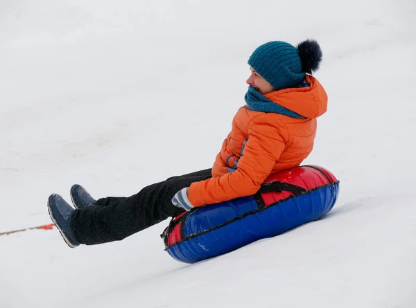 は雪のスライドをチューブに乗って楽しい時を過す — ストック写真