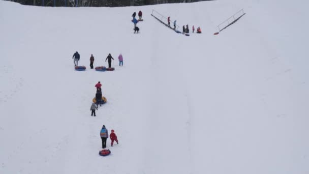 ローリング チューブ雪に覆われた丘の上の人々 が楽しくミンスク ベラルーシ 2019 — ストック動画