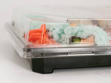 Suşi rulo set, soya sosu, wasabi tek kullanımlık bir kapsayıcı içindeki bir peçeteye