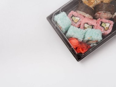 Suşi rulo set, soya sosu, wasabi tek kullanımlık bir kapsayıcı içindeki bir peçeteye