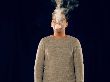 Genç adam elektronik sigara içiyor.