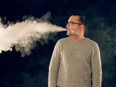 Genç adam elektronik sigara içiyor.