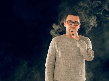 Genç adam elektronik sigara içiyor.