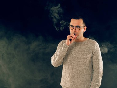 Genç adam elektronik sigara içiyor.