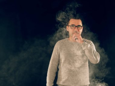 Genç adam elektronik sigara içiyor.