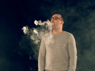 Genç adam elektronik sigara içiyor.