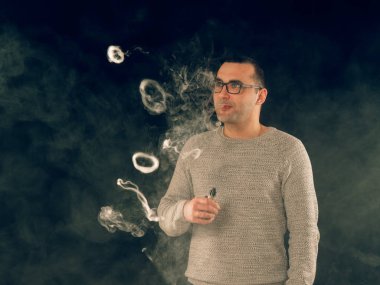 Genç adam elektronik sigara içiyor.