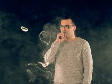 Genç adam elektronik sigara içiyor.