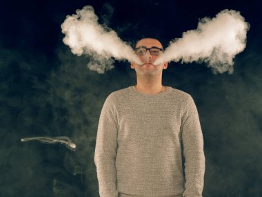 Genç adam elektronik sigara içiyor.