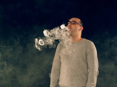 Genç adam elektronik sigara içiyor.