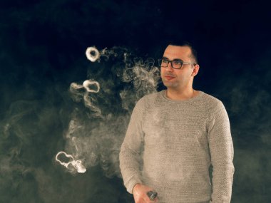 Genç adam elektronik sigara içiyor.