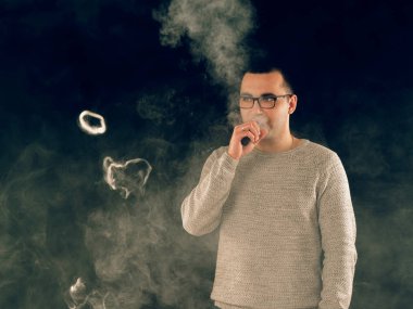 Genç adam elektronik sigara içiyor.