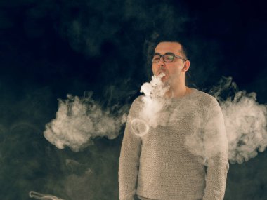 Genç adam elektronik sigara içiyor.