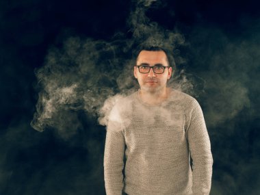 Genç adam elektronik sigara içiyor.